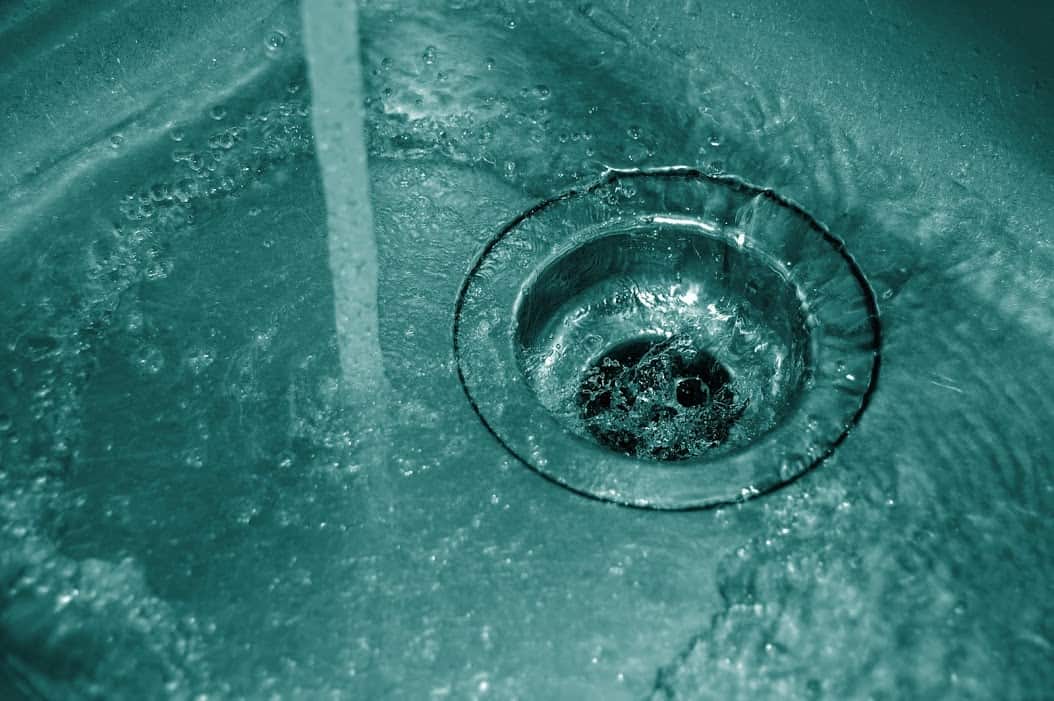 water running from the sink into the drain